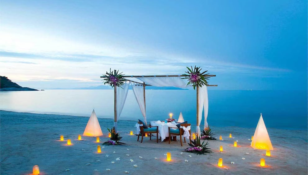 Cena privada en la playa iluminada por el atardecer