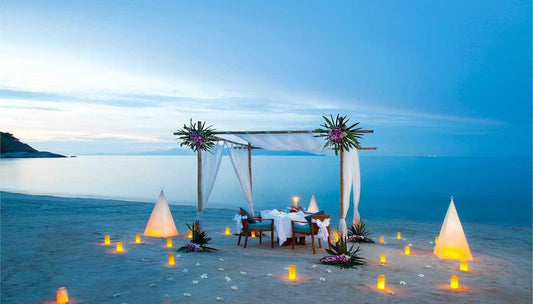 Cena privada en la playa iluminada por el atardecer
